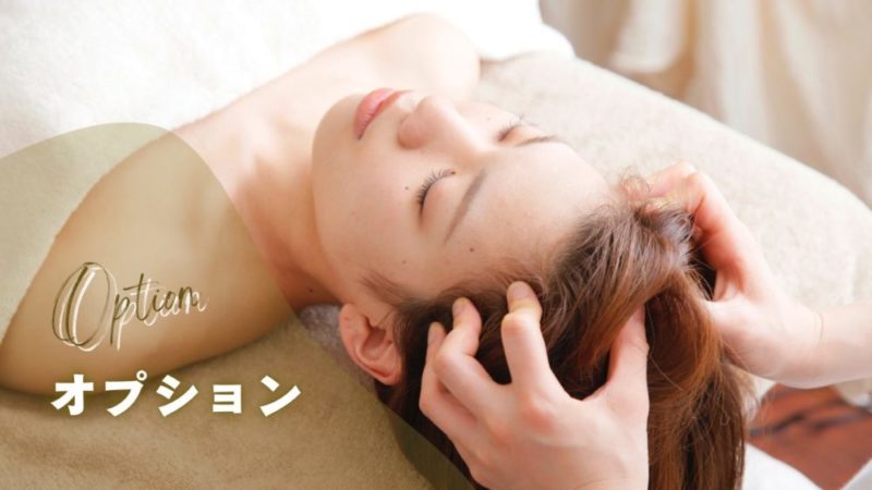 リラクゼーション中にヘッドスパを受けている女性の写真